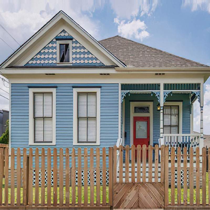 A blue home surrounded by a picket fence